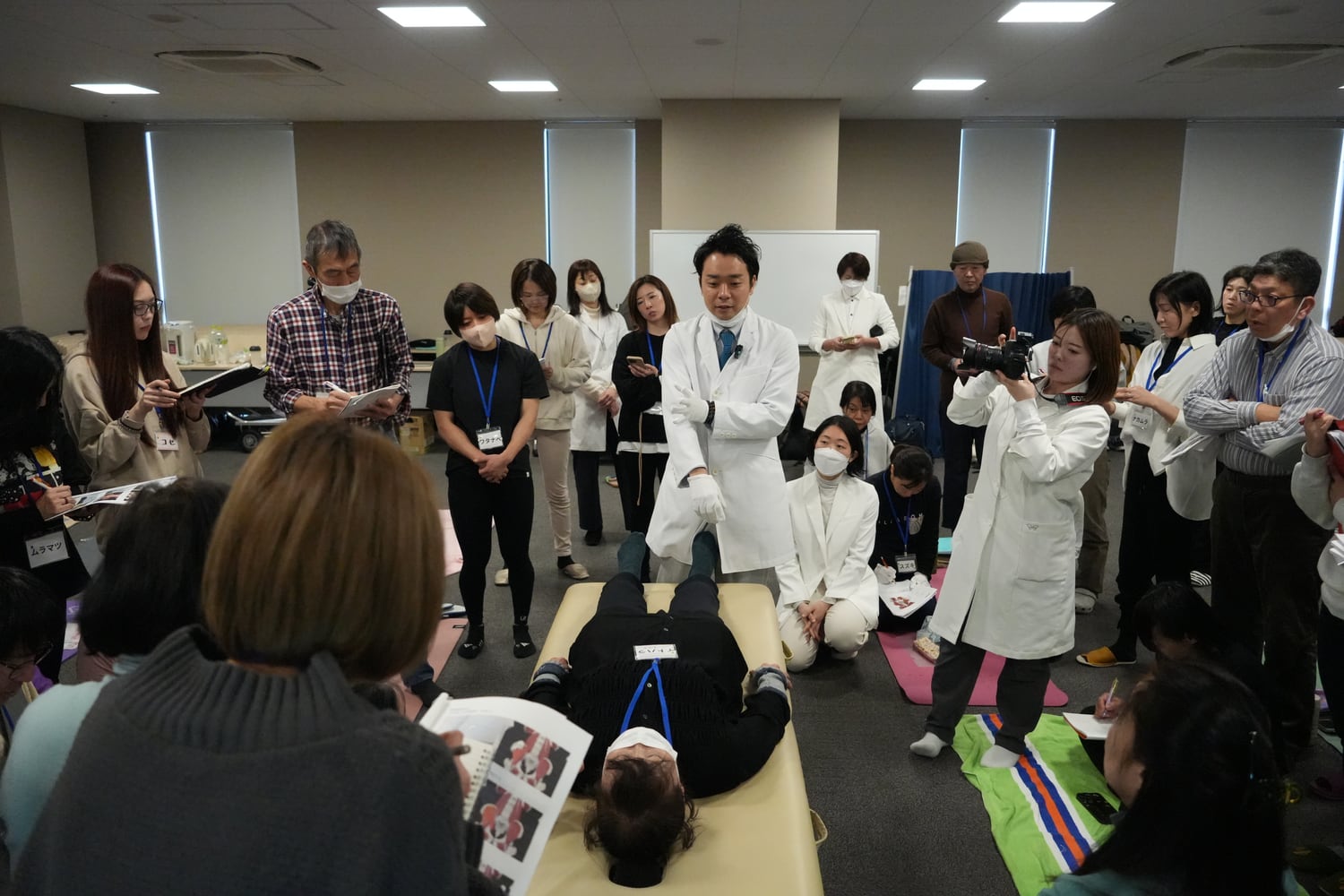 施術台の参加者に手技を実演する藤井翔悟